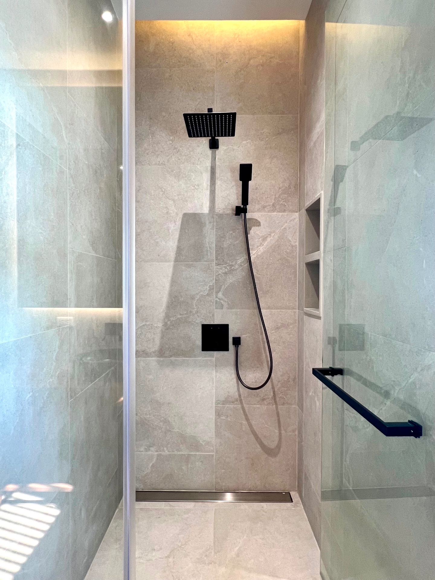En-suite bathroom with stone tiles and walk-in rain shower