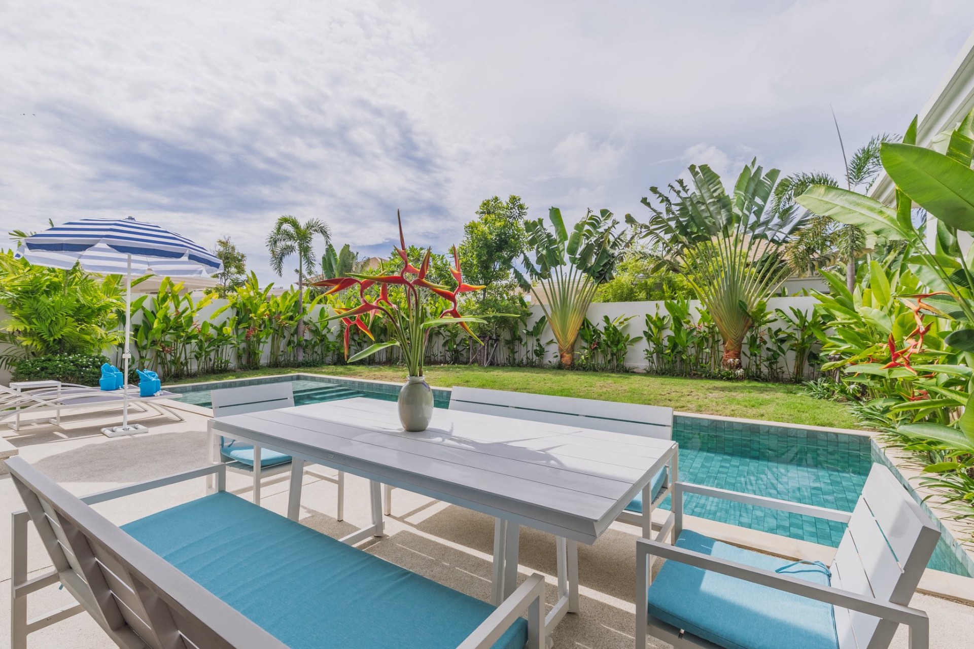 Pool terrace with outdoor dining and tropical garden