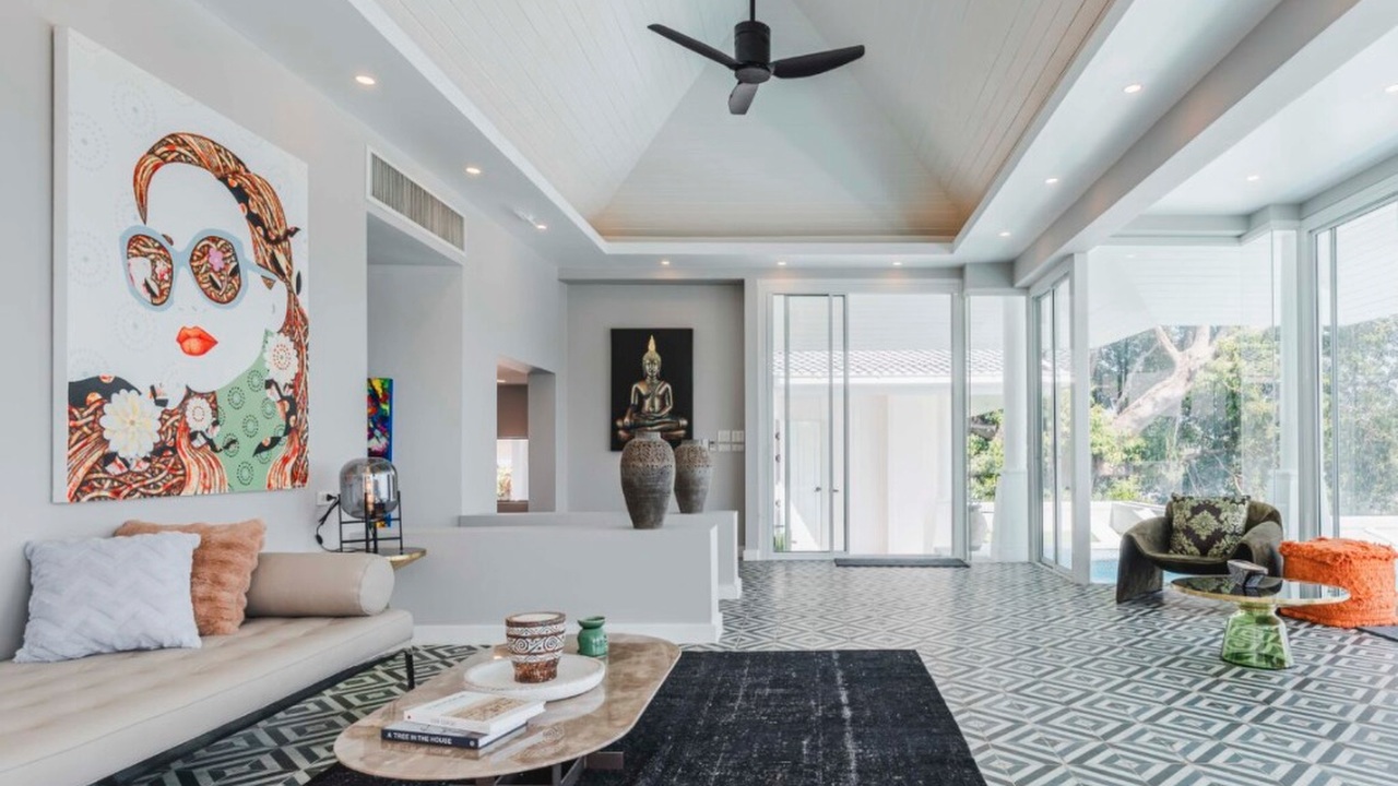 Living room with pop-art portrait, beige sofa and vaulted ceiling