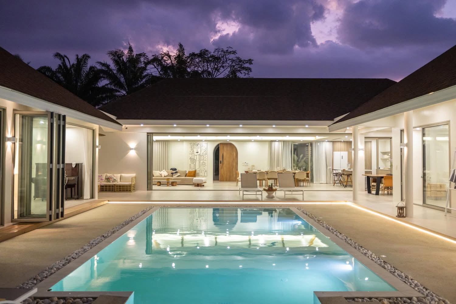 Illuminated villa and pool at twilight