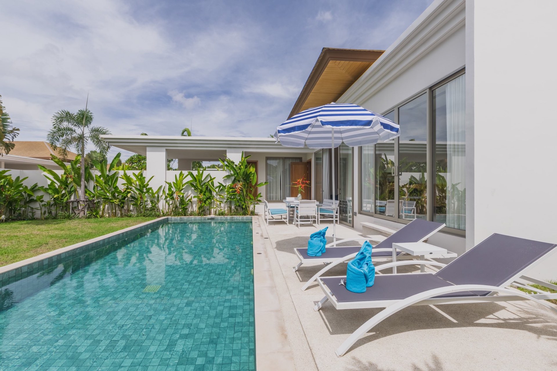 Pool deck with umbrella and sun loungers