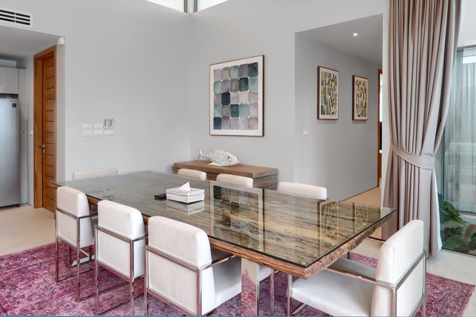 Dining room with glass-top table and curated artwork