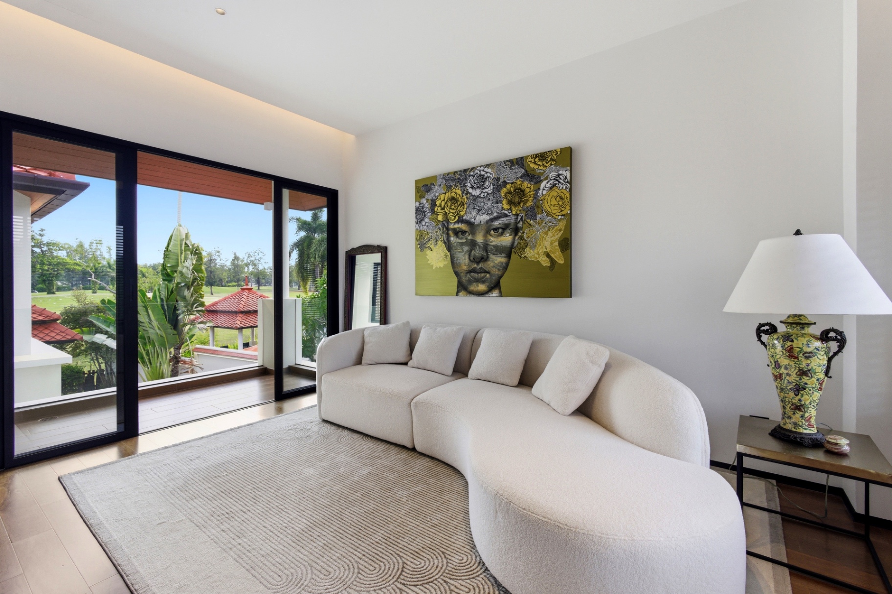 Bright lounge corner with golf view balcony and statement artwork