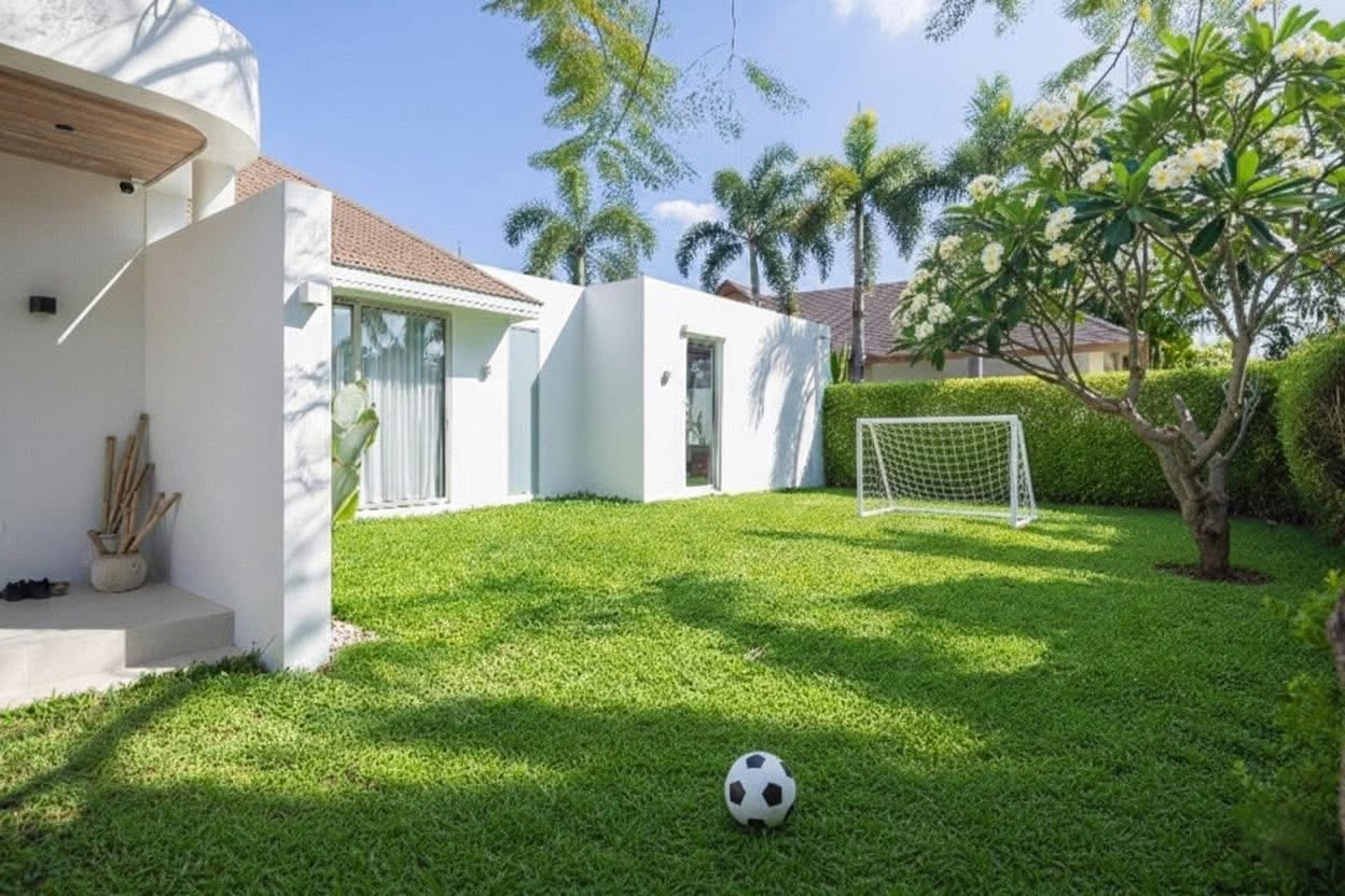 Landscaped garden lawn with football goal and frangipani tree