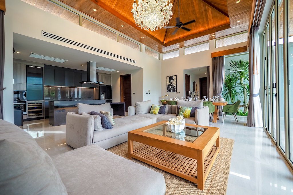Open-plan living room with designer sofas and view to the kitchen