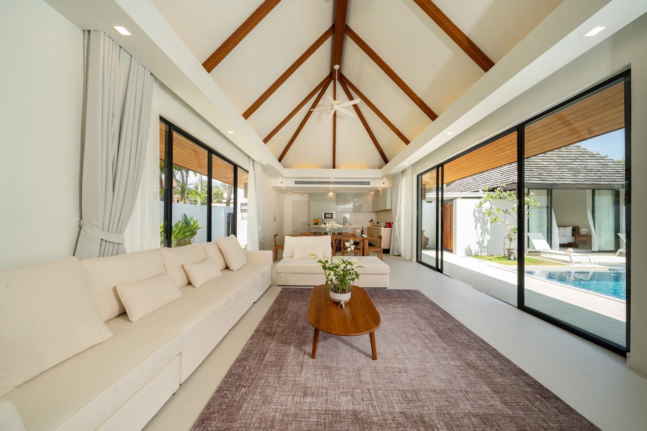 Living room with vaulted timber ceiling opening to the pool terrace