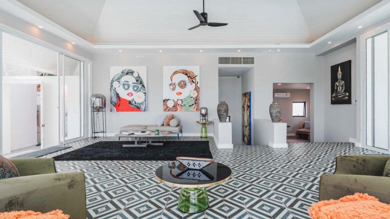 Grand triple-volume lounge with pop-art portraits and geometric tile flooring