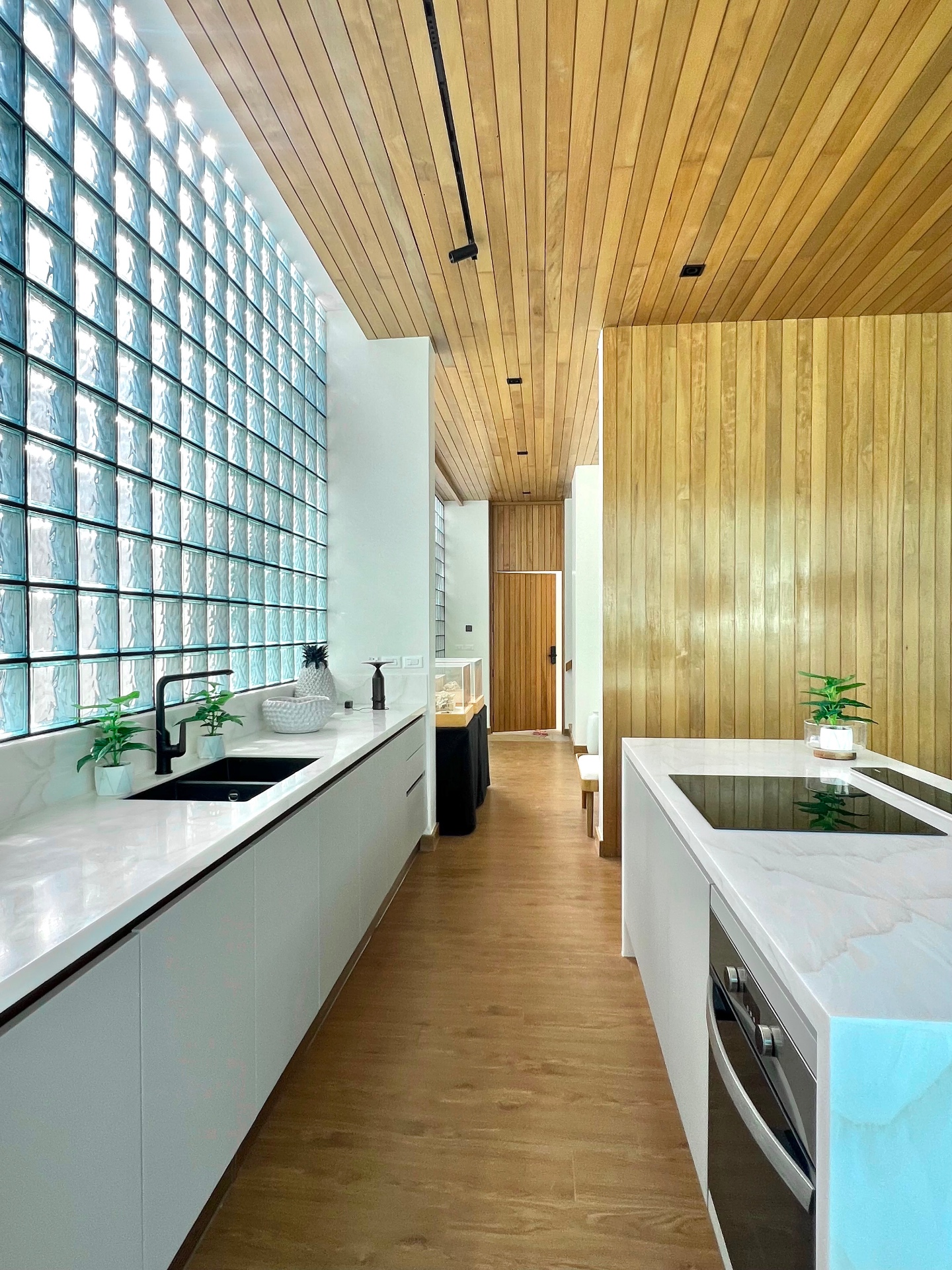 Modern white kitchen with marble island and glass-block feature wall