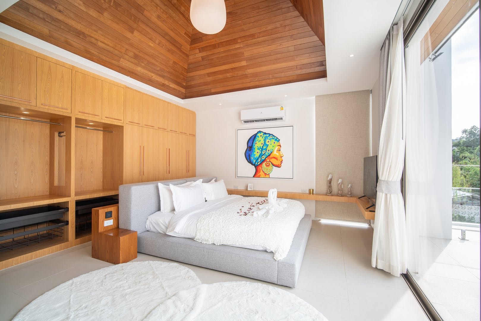 Bedroom with vaulted timber ceiling and statement artwork