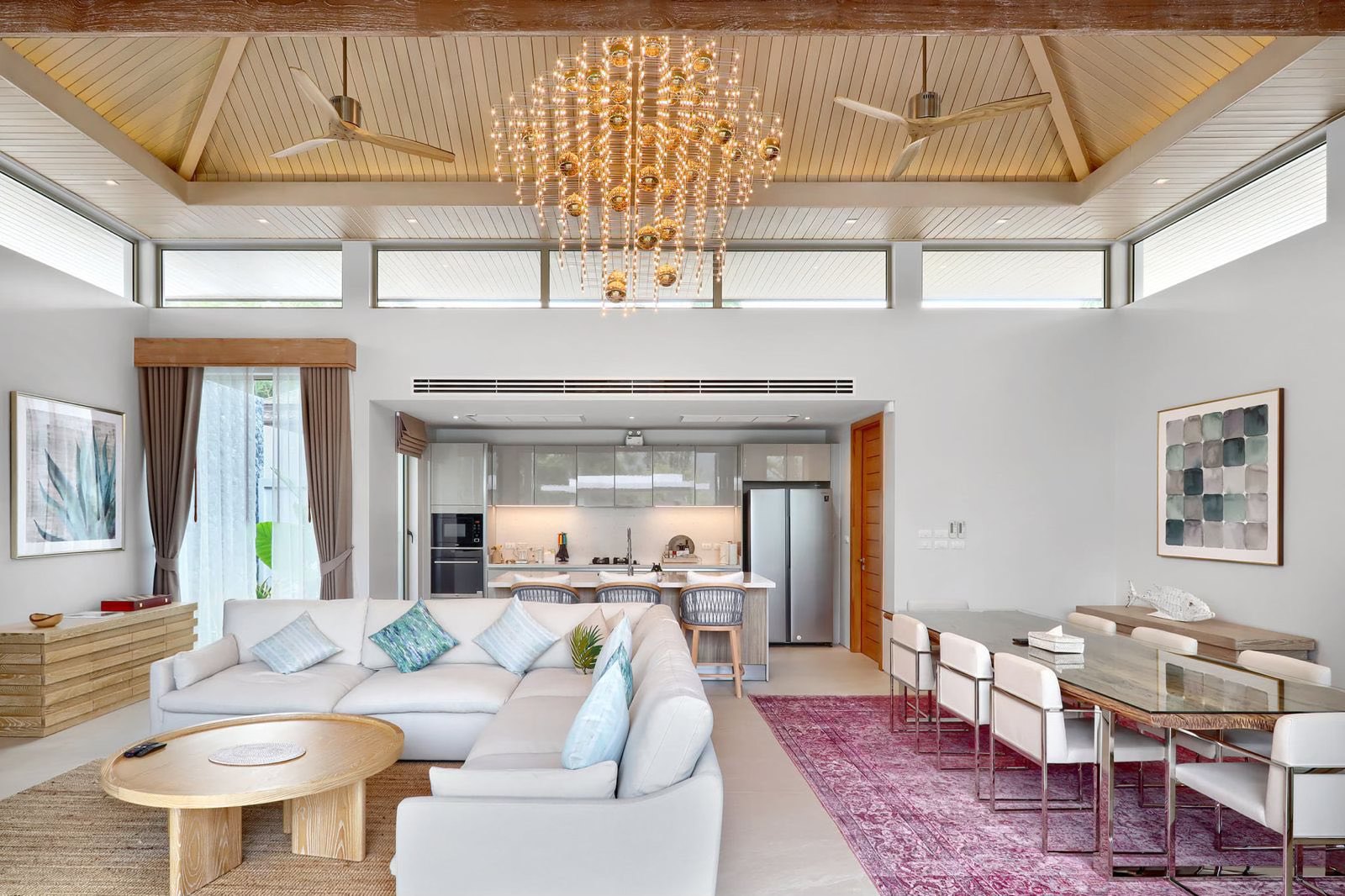 Open-plan living, dining and kitchen with vaulted ceiling and chandelier
