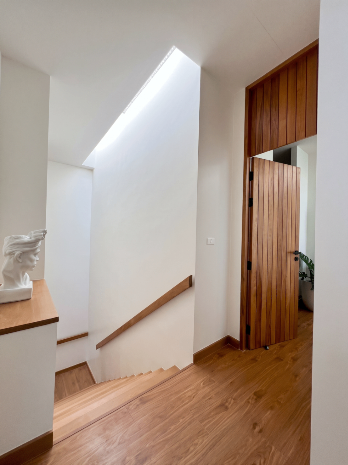 Timber staircase landing with skylight and minimalist detailing