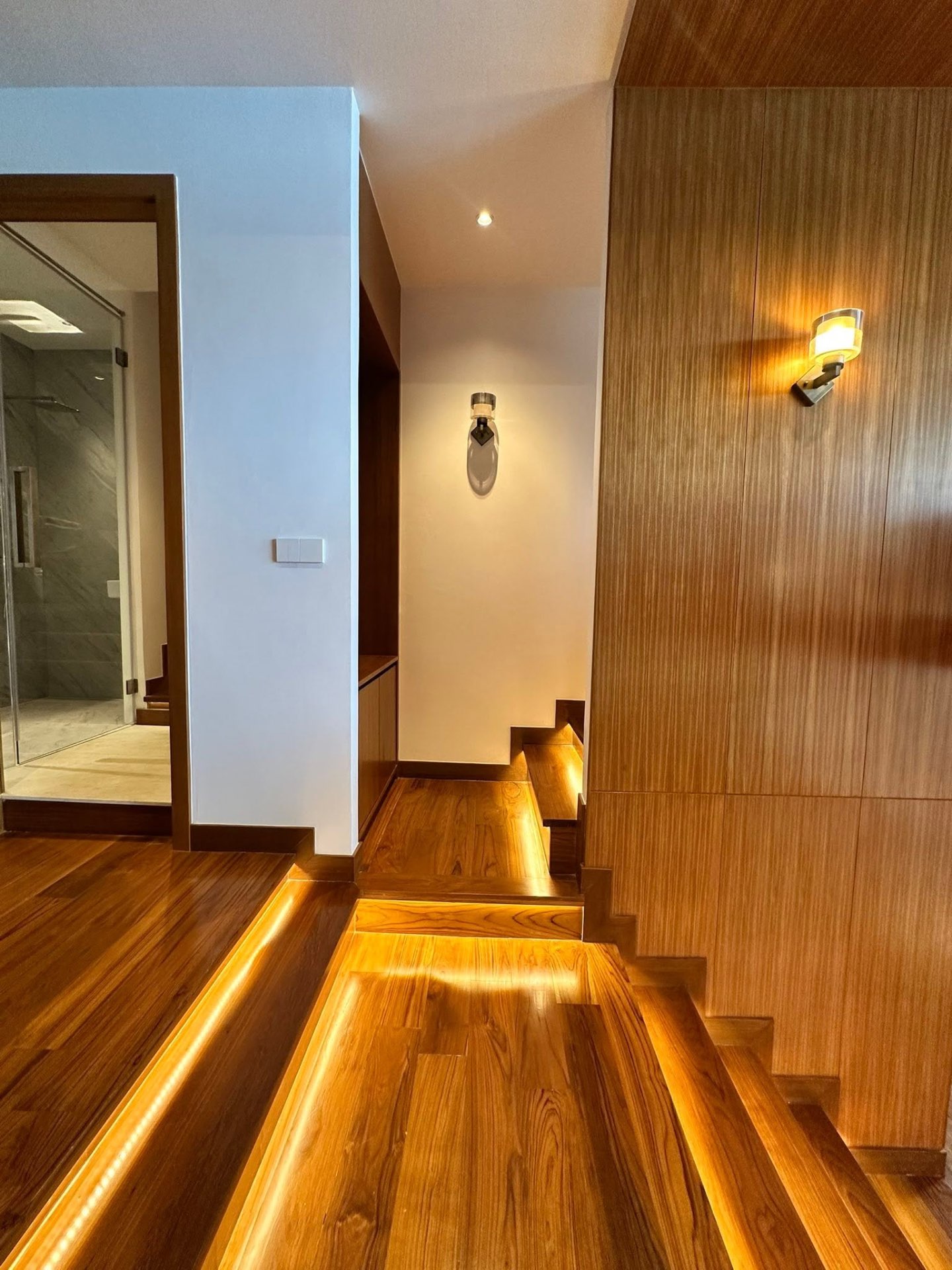 Teak staircase with LED step lighting connecting the duplex levels