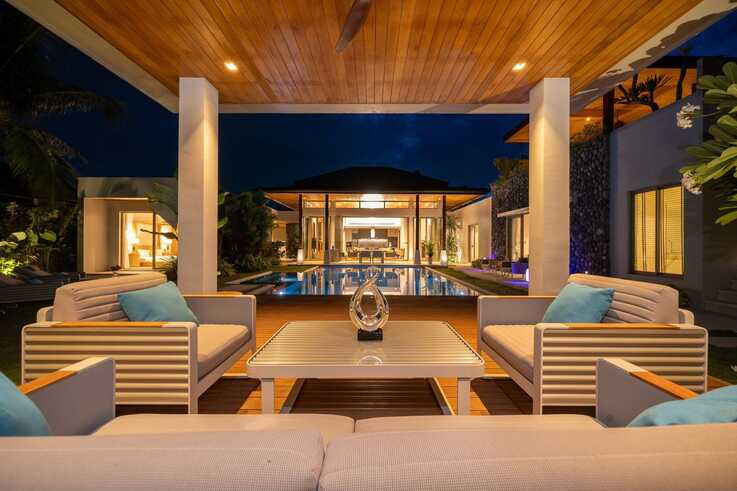 Outdoor lounge with pool view at night