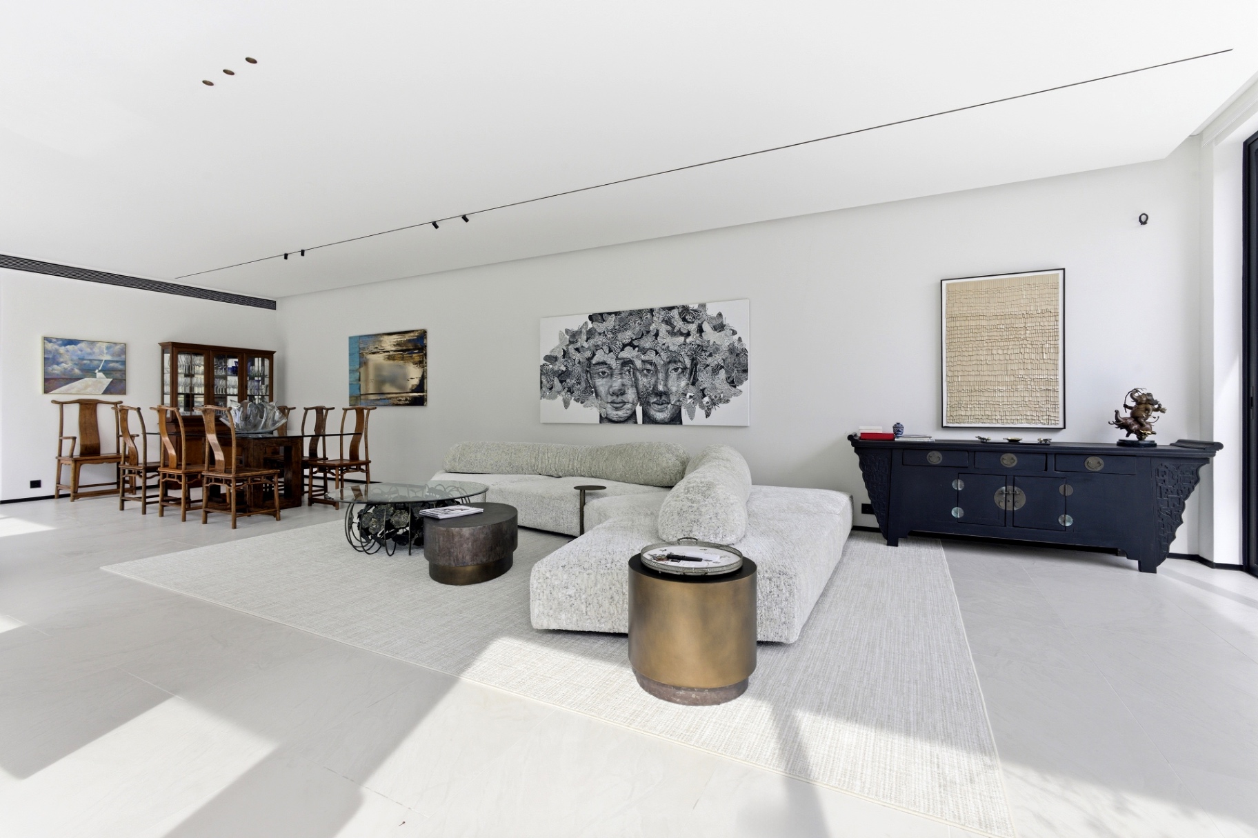 Open-plan living and dining area with oversized sofa and art pieces