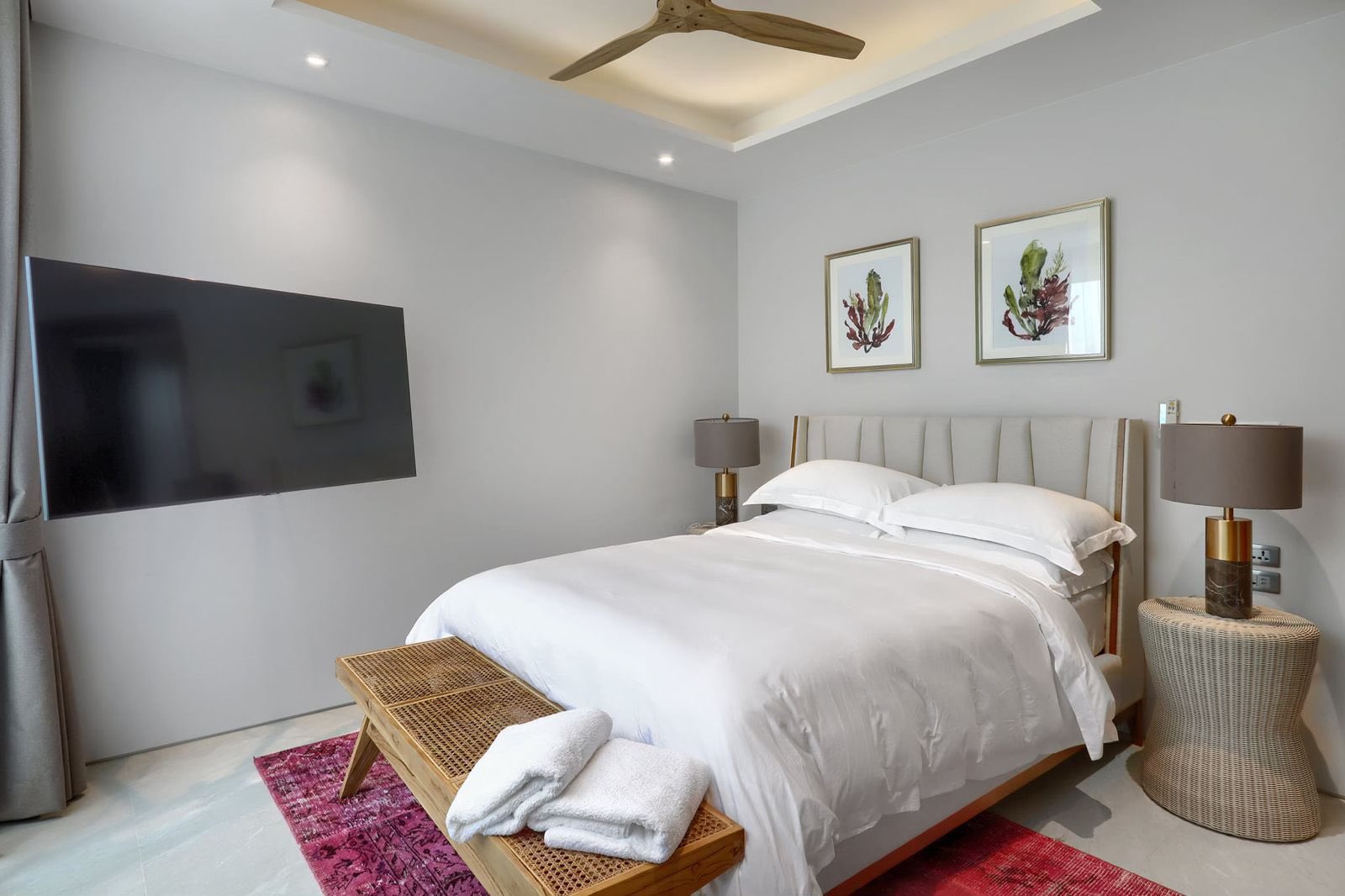 Guest bedroom with wall-mounted TV and watercolour artwork