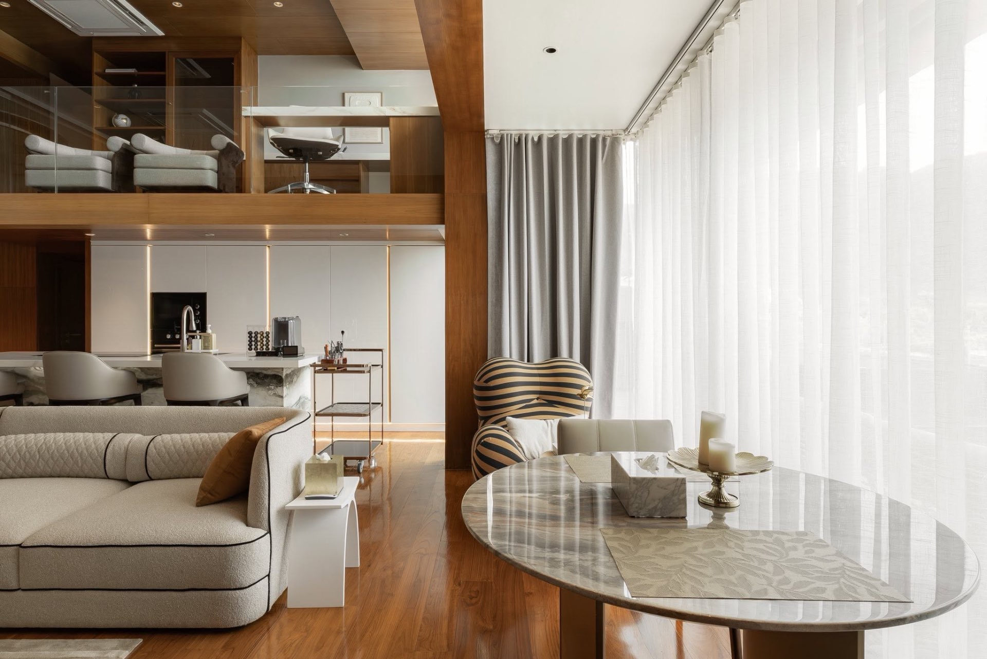 Dining and lounge area with marble table, sheer drapes and sea views