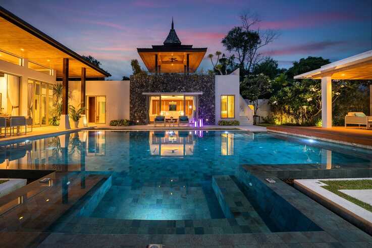 Stone-clad pavilion and pool at sunset