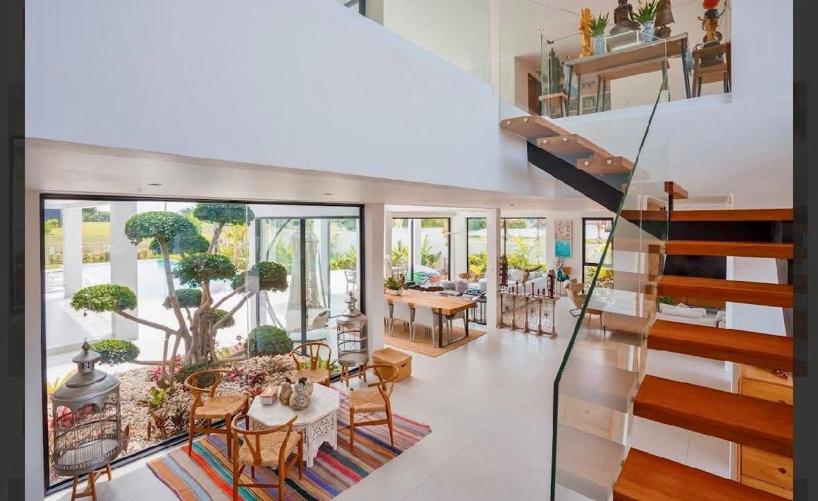 Double-height atrium with floating timber staircase and bonsai courtyard