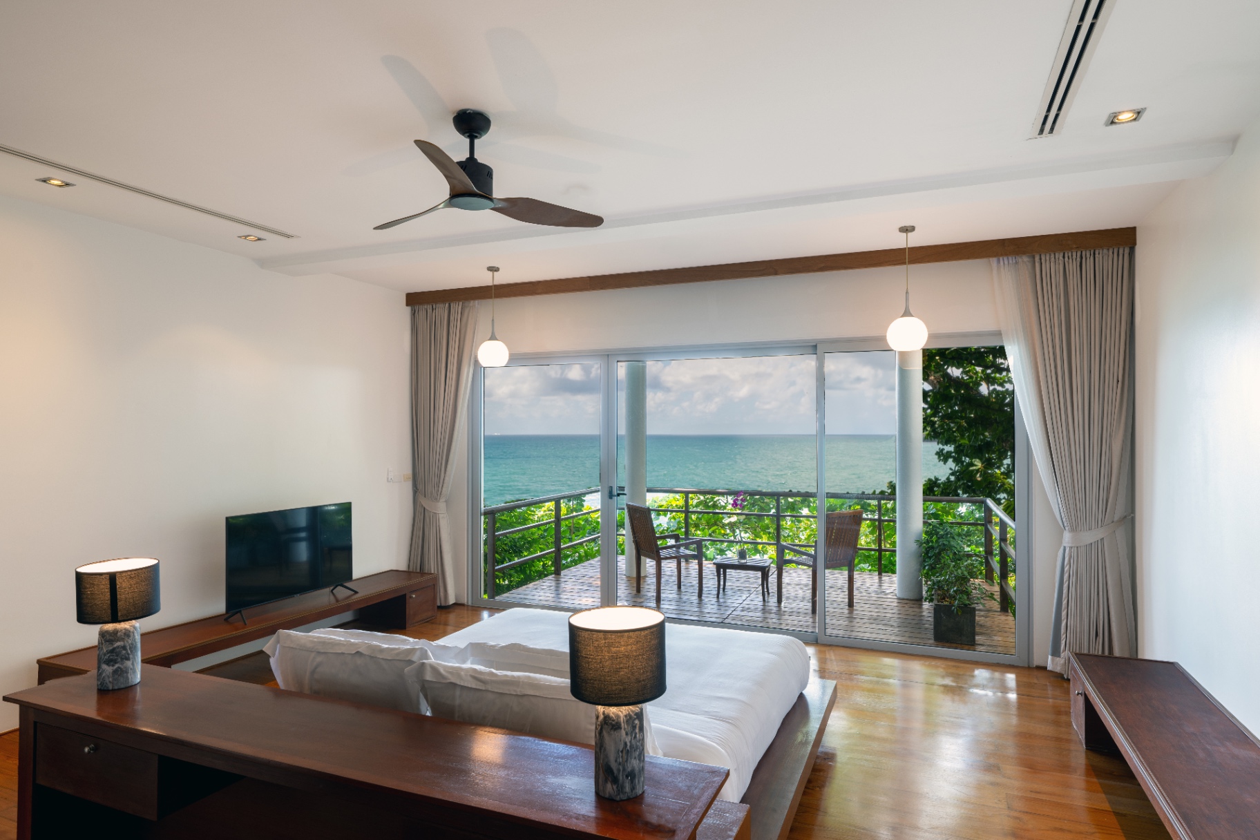 Sea-view bedroom opening to a private balcony deck