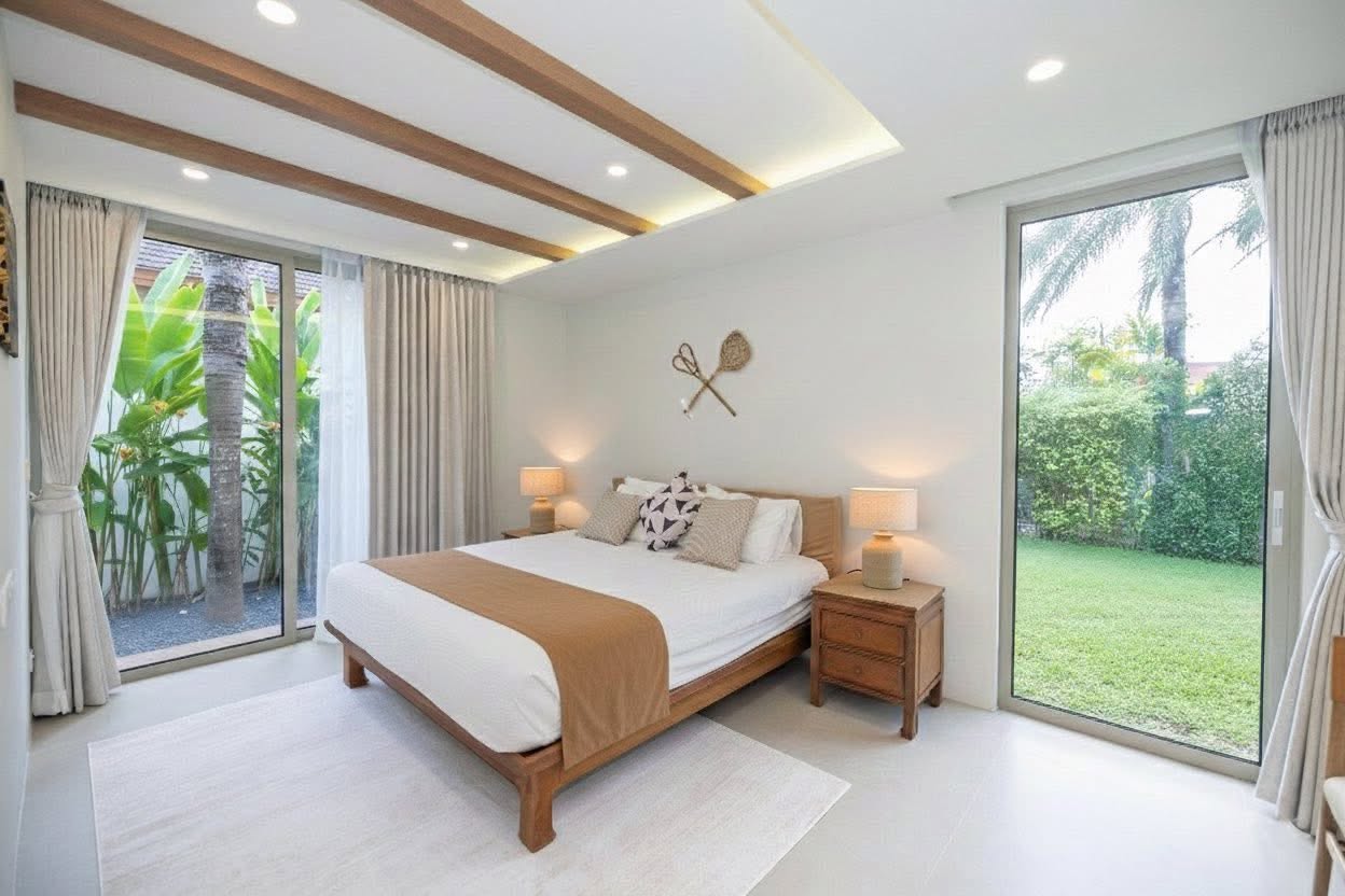 Guest bedroom with timber bed and garden palm views