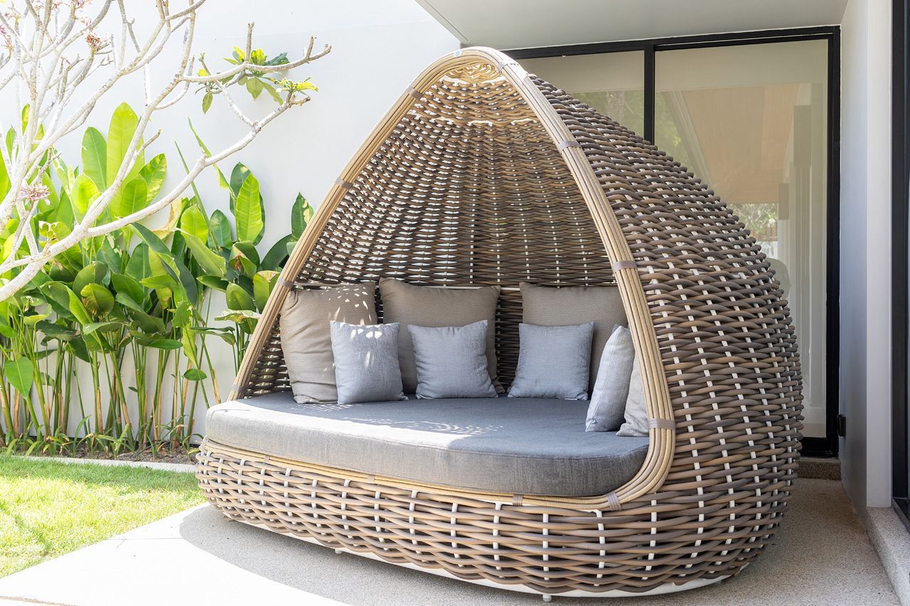 Outdoor rattan daybed nestled in the tropical garden