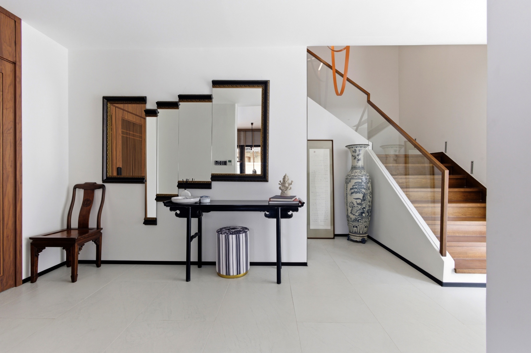 Entrance foyer with decorative console, mirrors and timber staircase