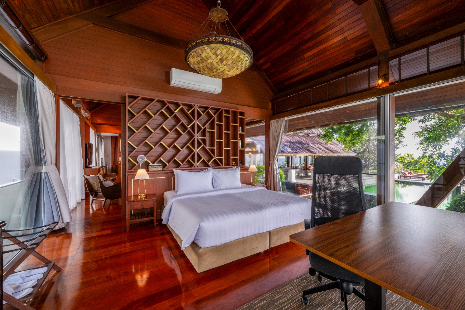 Bedroom with carved teak headboard and pool view