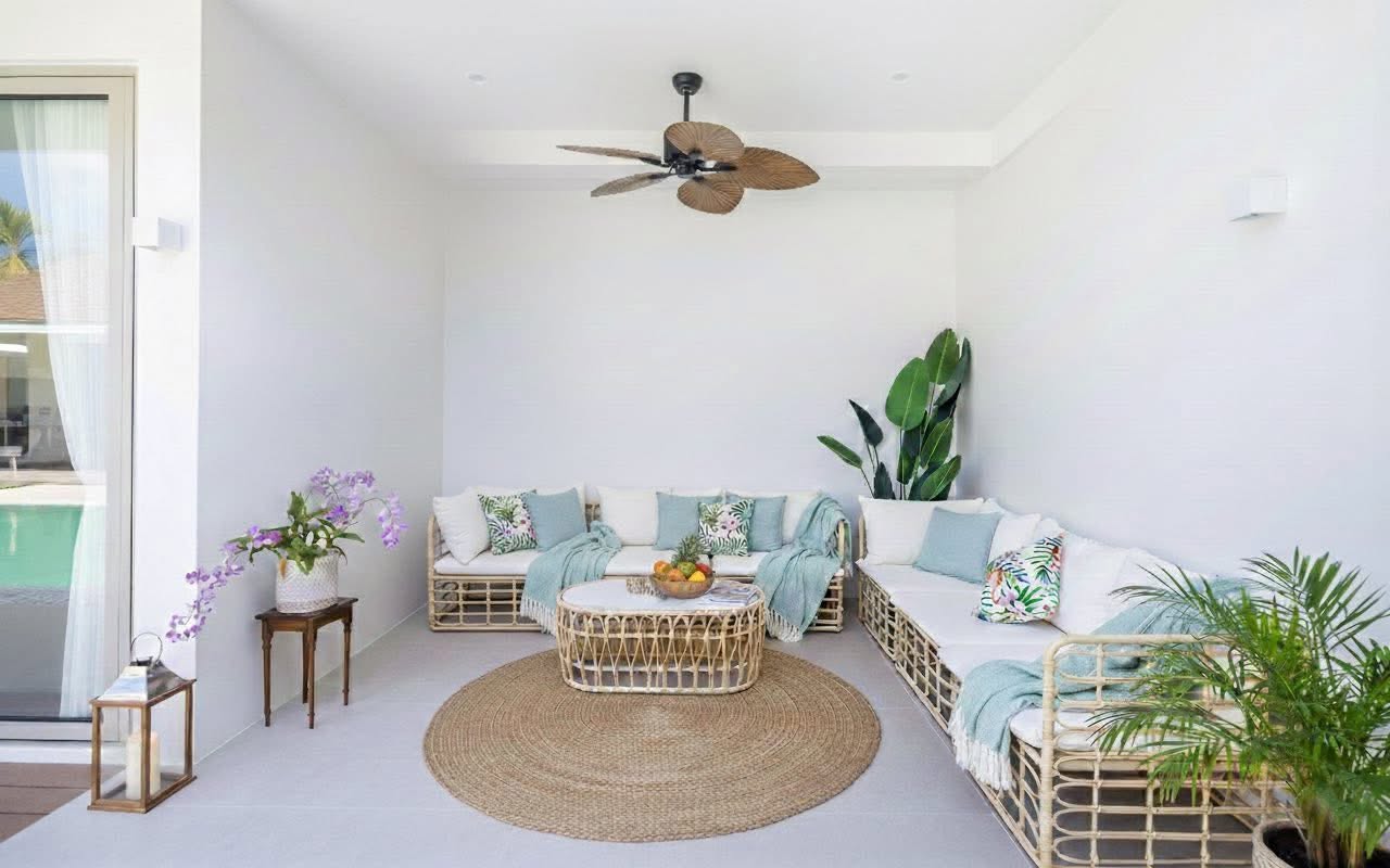 Covered outdoor lounge with rattan seating beside the pool