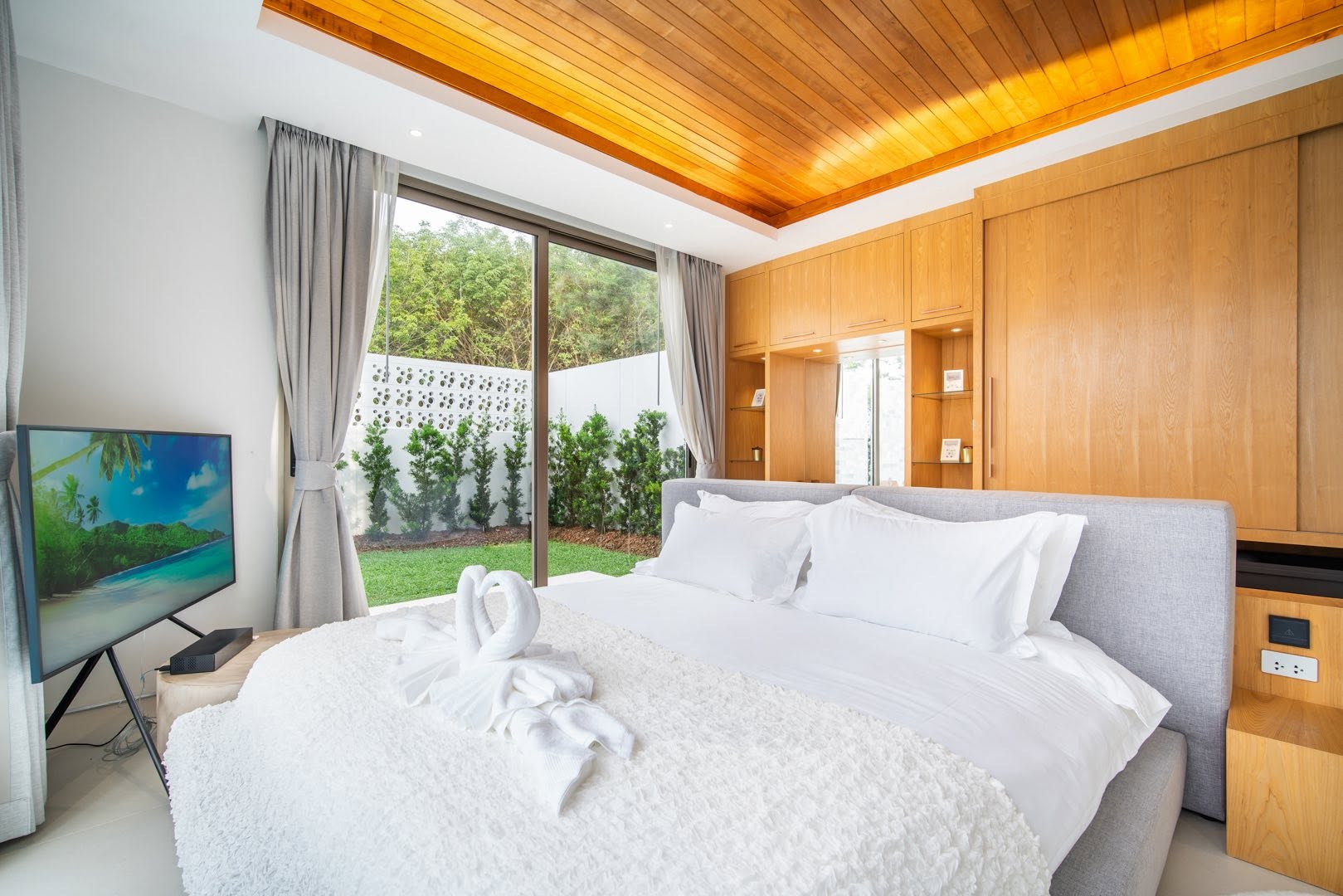 Guest bedroom with timber ceiling and garden outlook