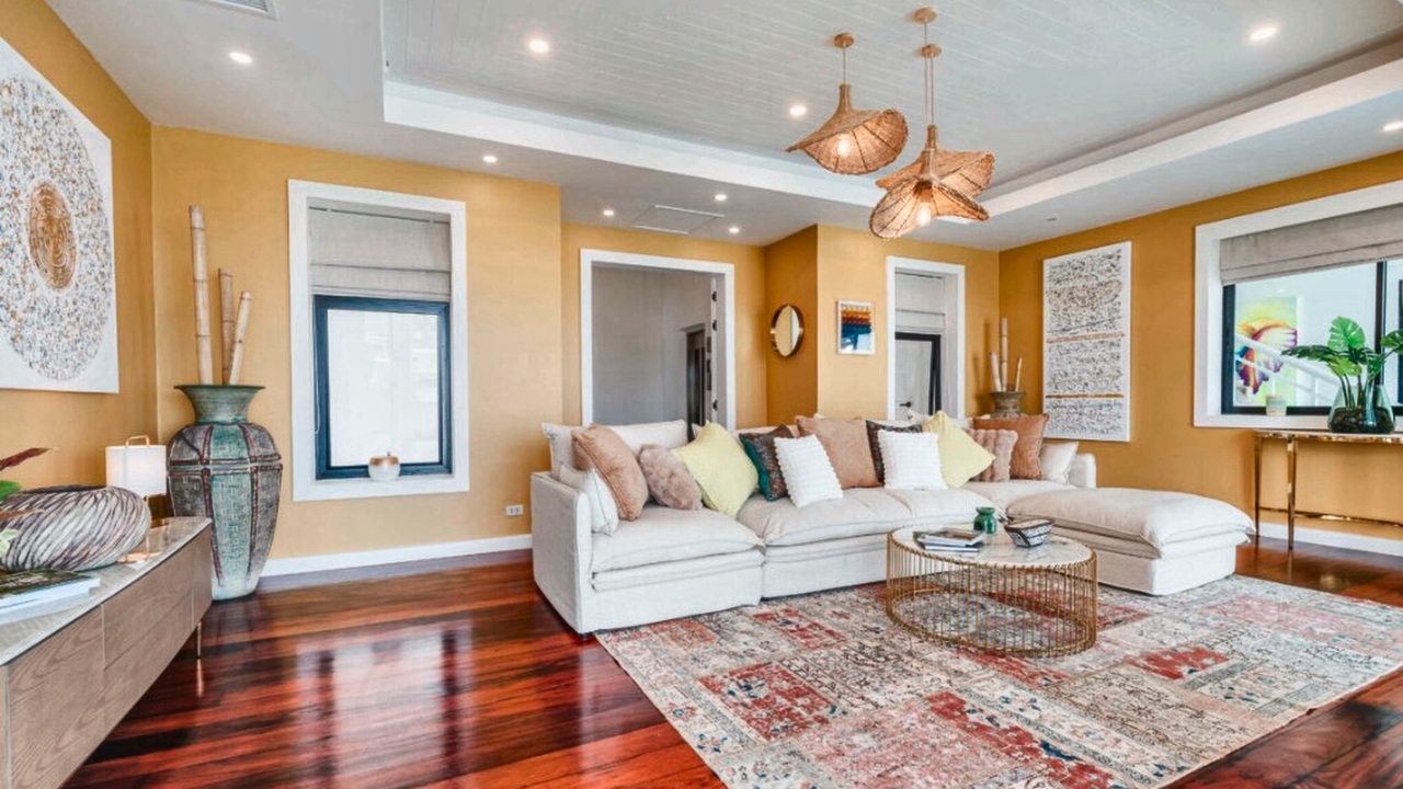 Living room with hardwood floor, sectional sofa and rattan pendants