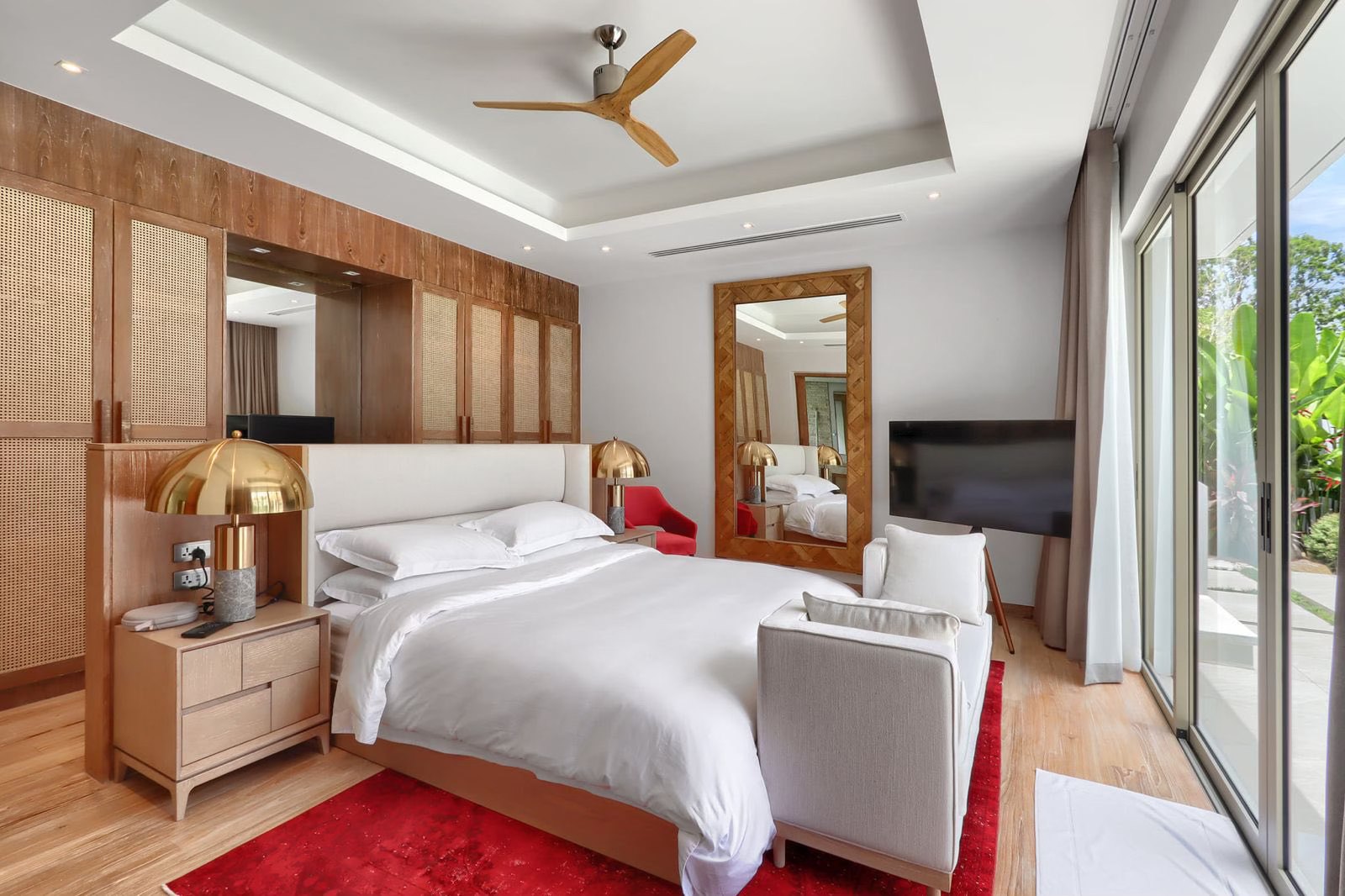 Master bedroom with timber-framed mirror and garden access