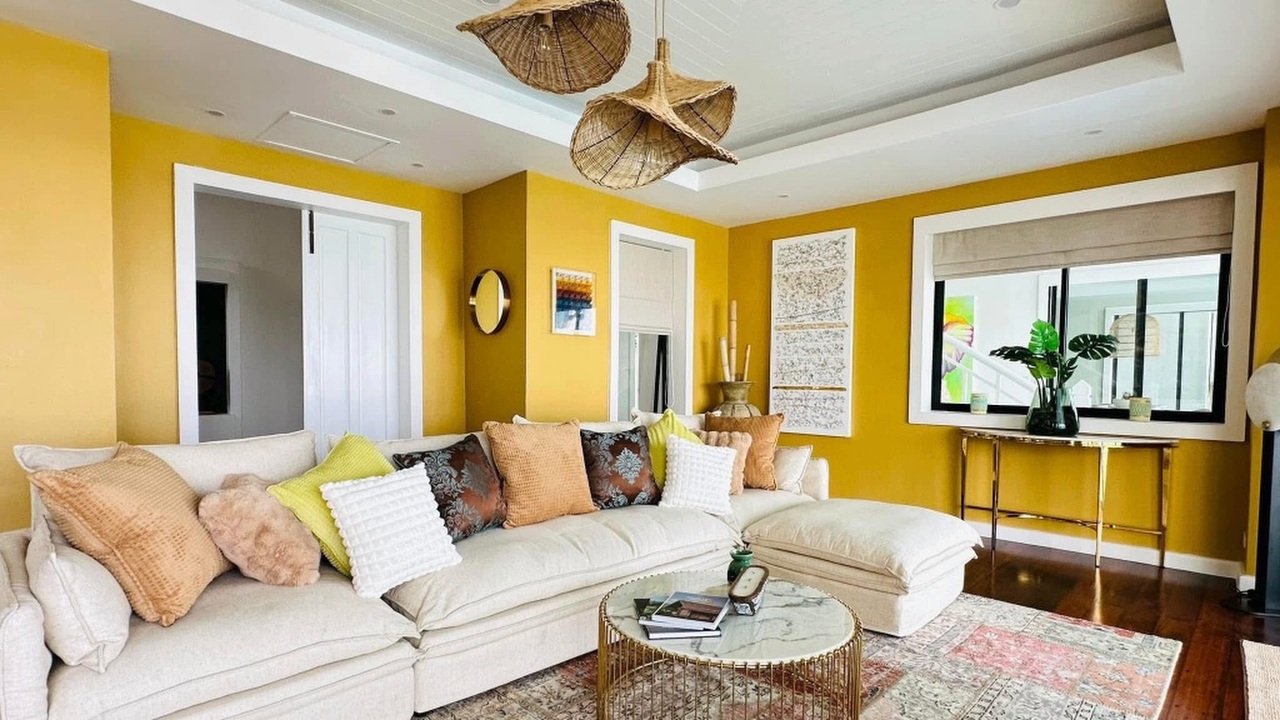 Sitting room with cream sectional sofa and warm ochre walls