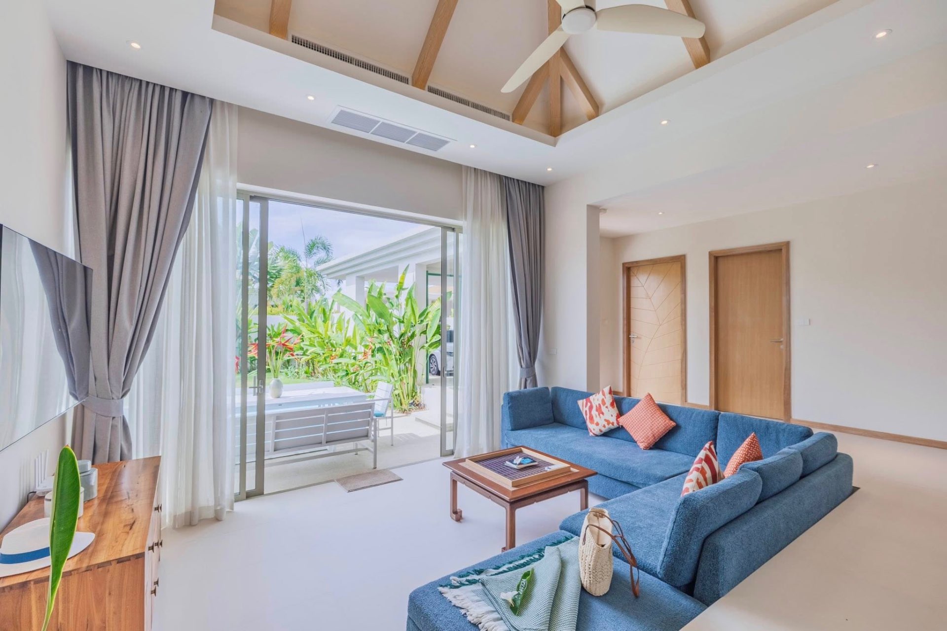 Living room with blue sectional sofa and pool terrace access