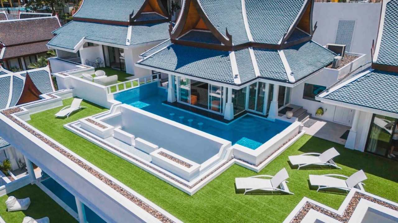 Rooftop infinity pool and sun terrace beneath a traditional Thai roof