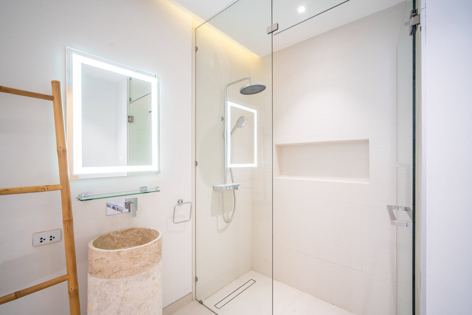 Walk-in rain shower with stone pedestal basin