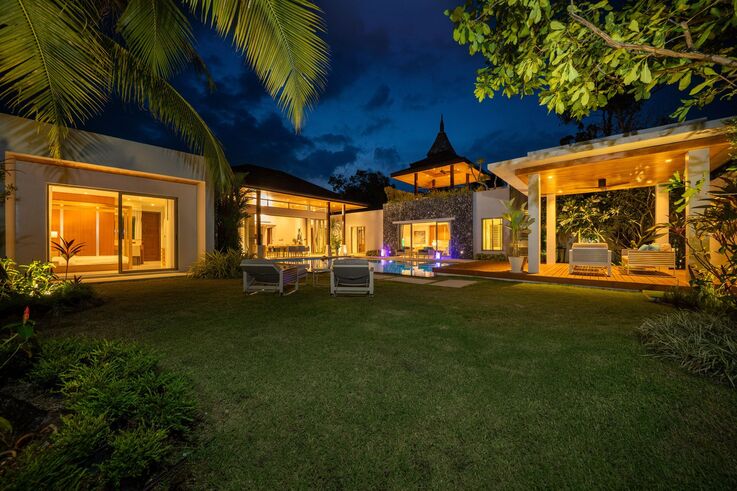 Garden lawn and illuminated villa at night