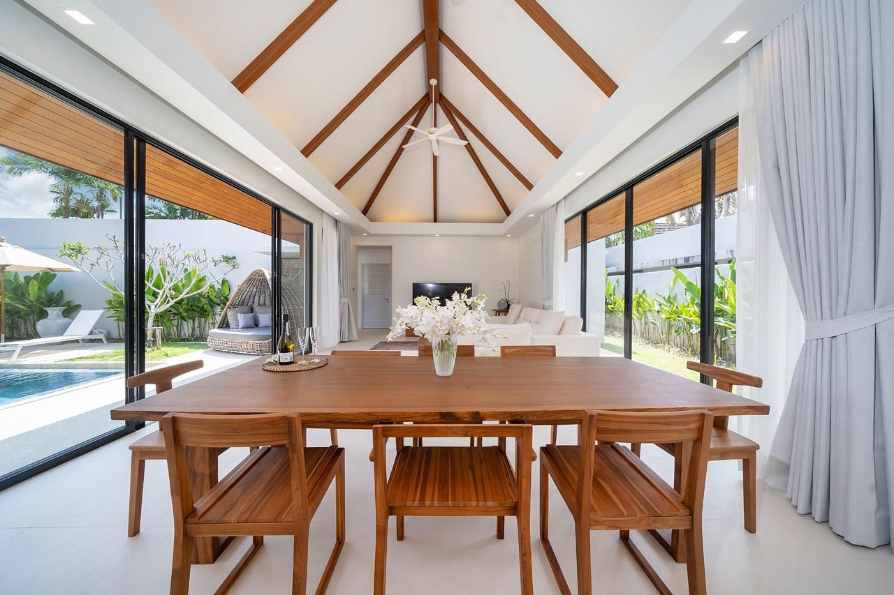 Dining area with timber dining table beneath a vaulted ceiling