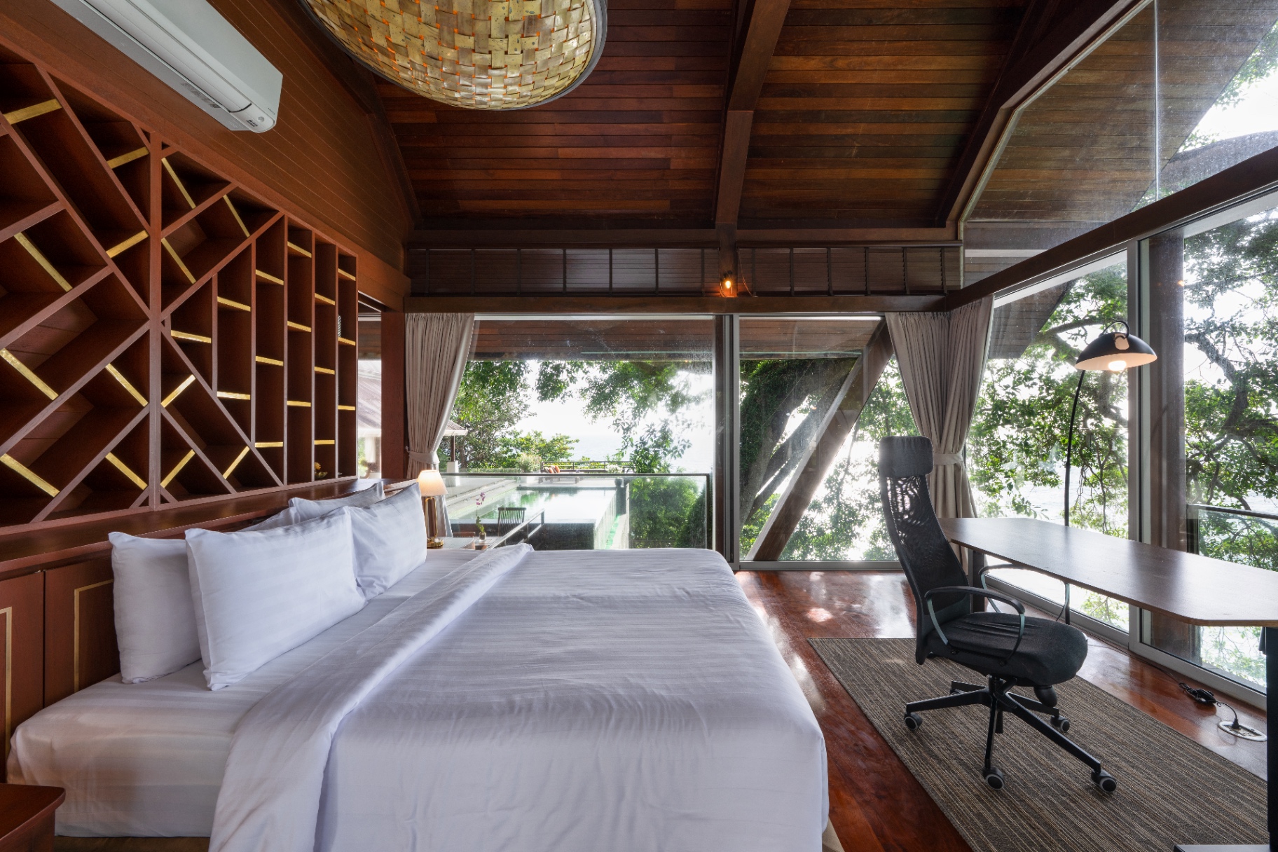 Sea-view bedroom with workspace and floor-to-ceiling glass