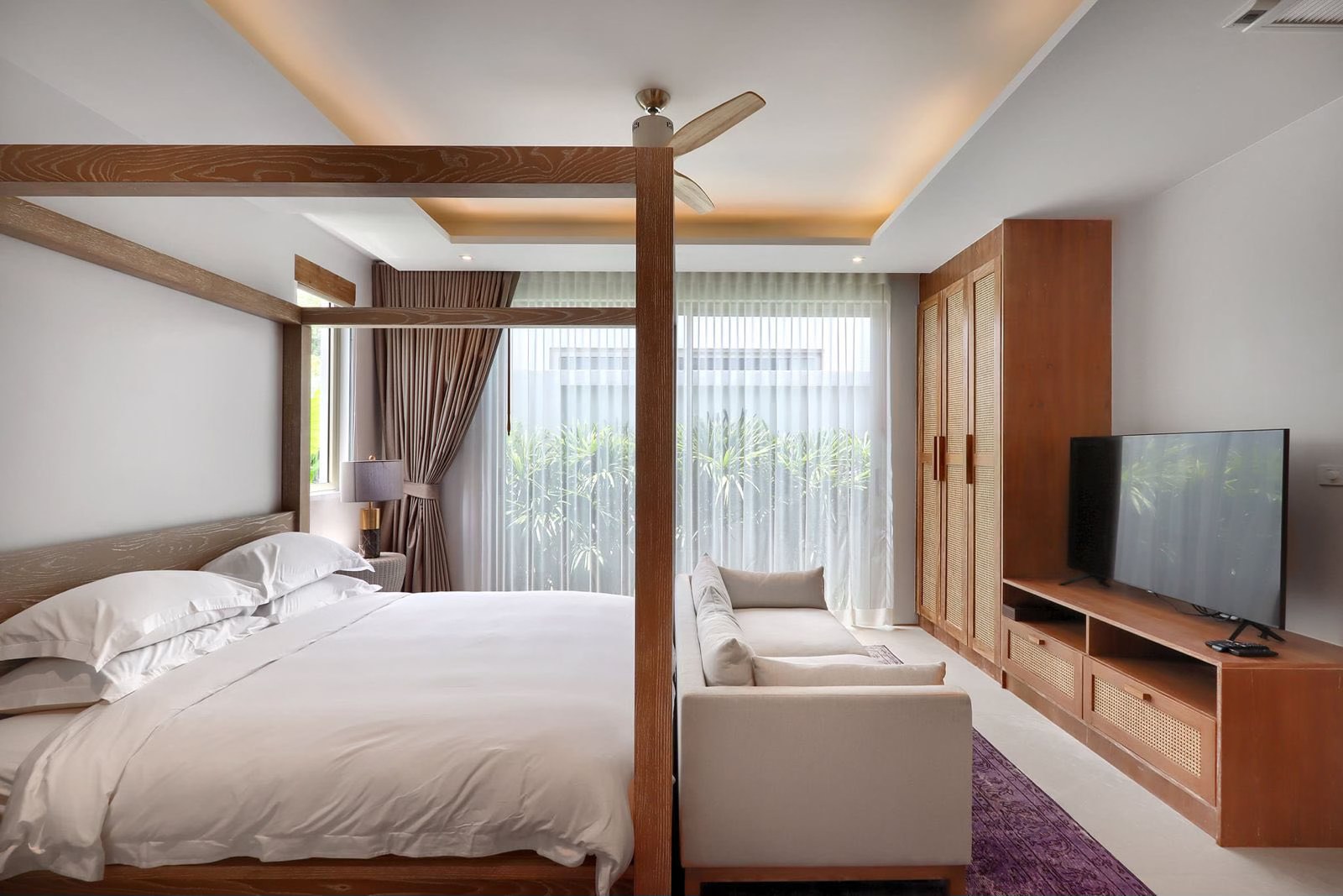 Master bedroom with four-poster bed and lounge seating