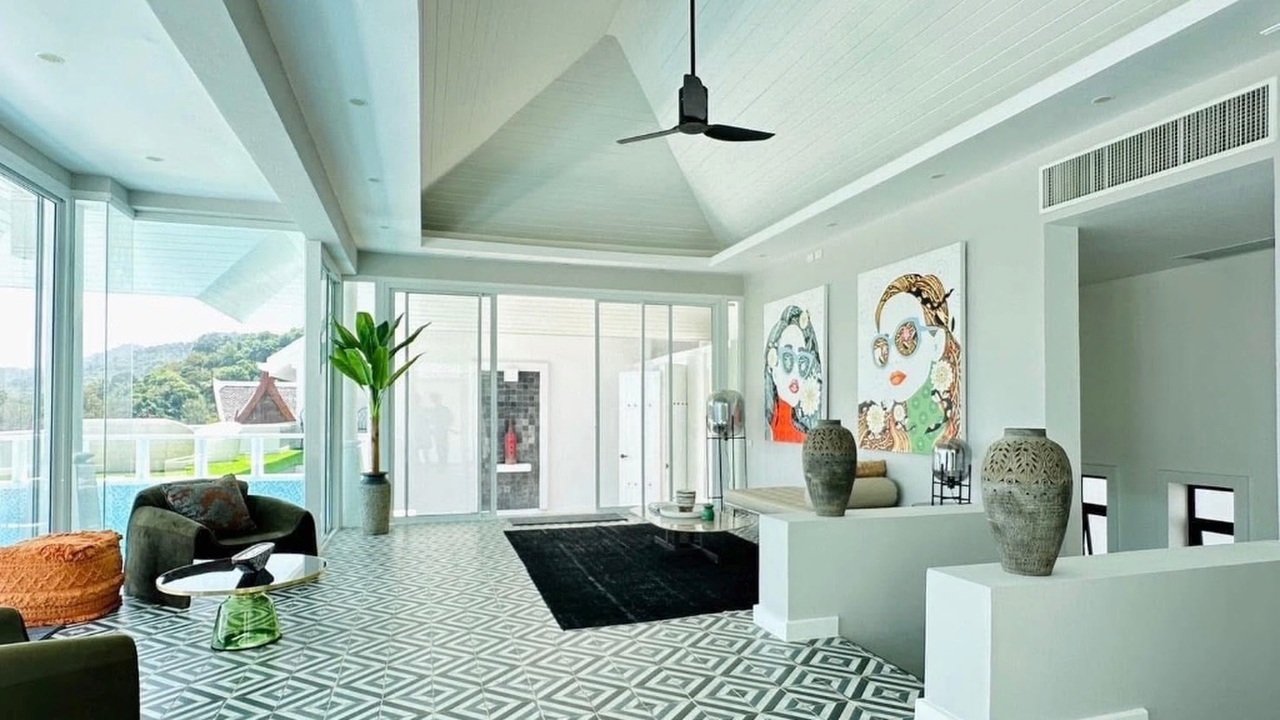 Triple-volume living area with floor-to-ceiling glass and pool views