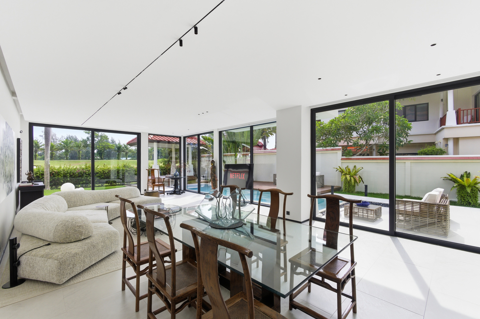 Open-plan living and dining room opening to the pool and golf course