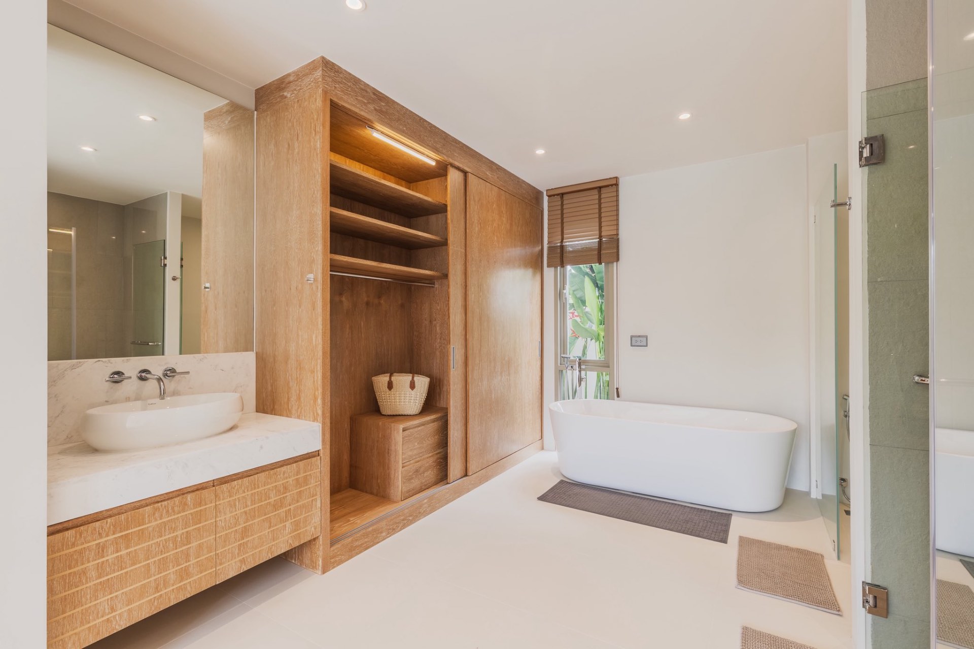 Bathroom with marble vanity, wardrobe and freestanding tub