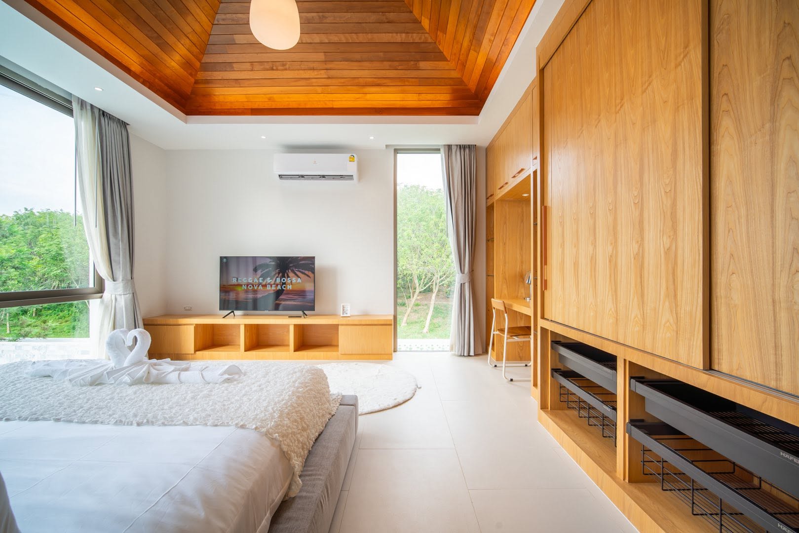 Bedroom with timber ceiling, TV and garden view