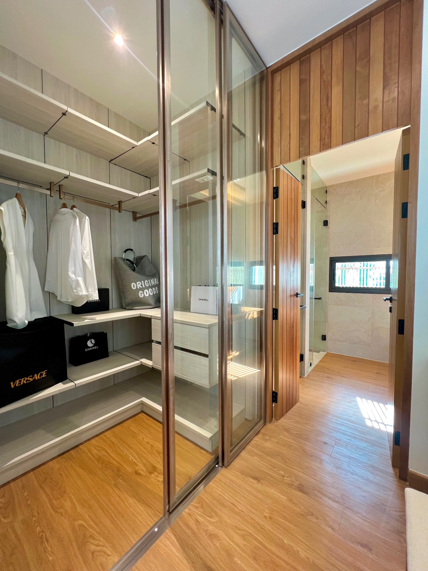 Walk-in wardrobe and dressing room with glass cabinetry