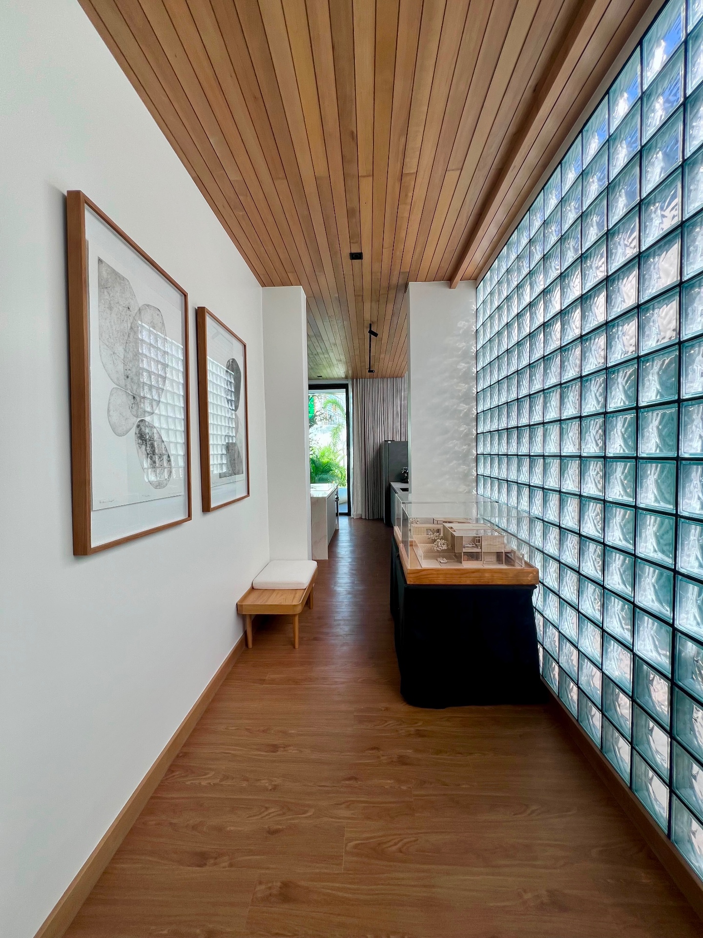 Interior corridor with framed art and warm timber flooring