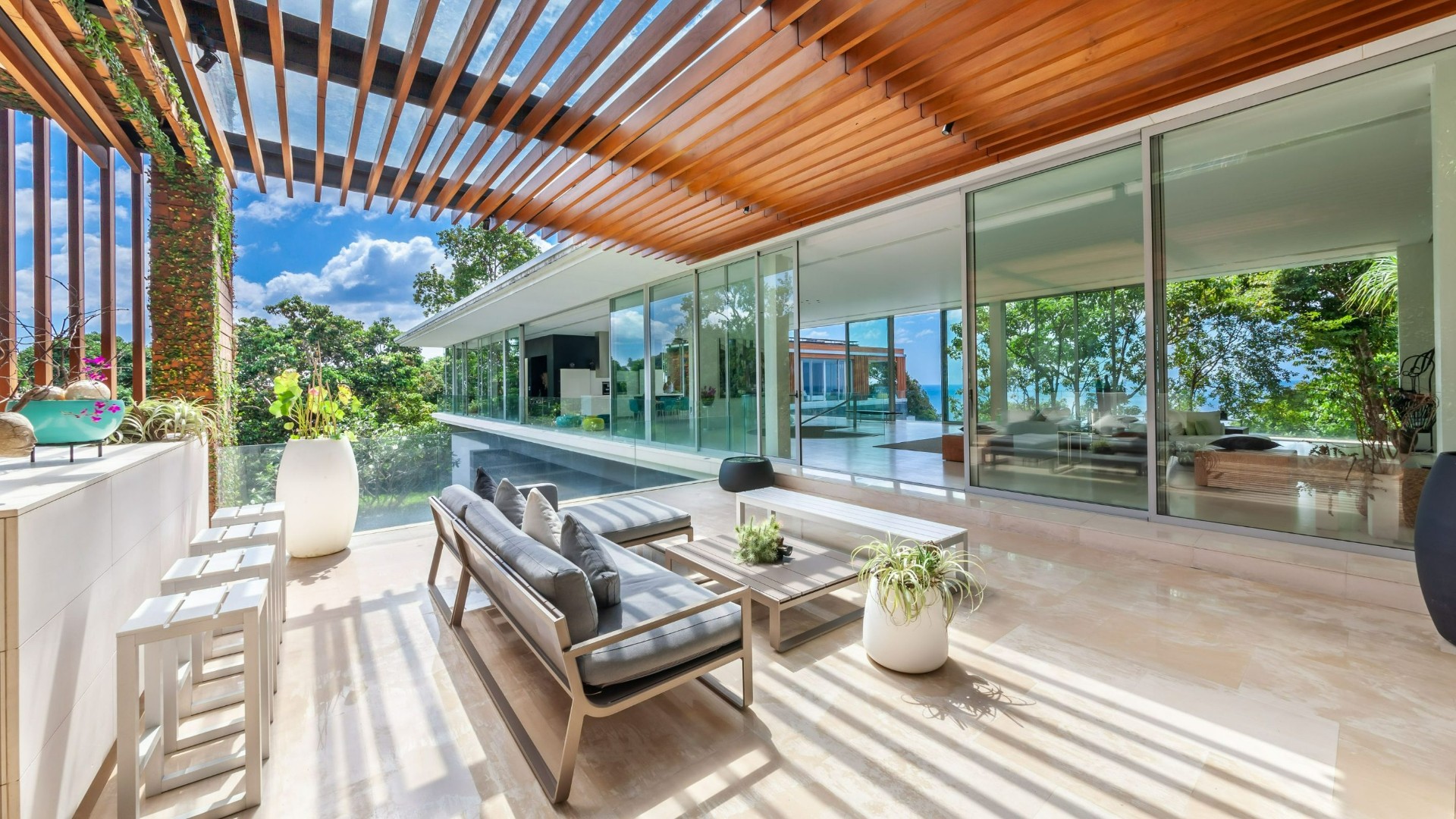 Open-air terrace lounge with floor-to-ceiling glass