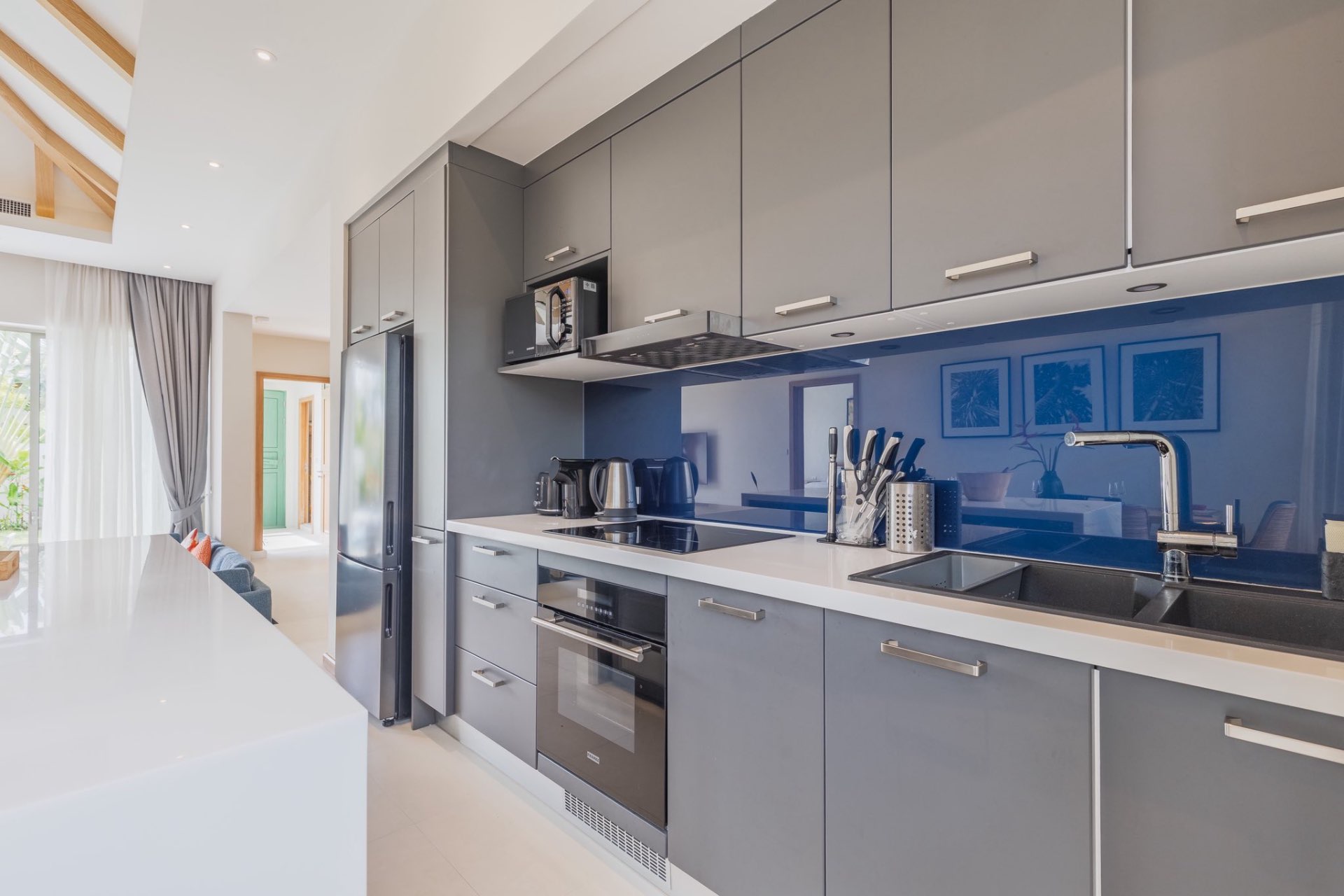 Modern grey kitchen with blue glass splashback and appliances