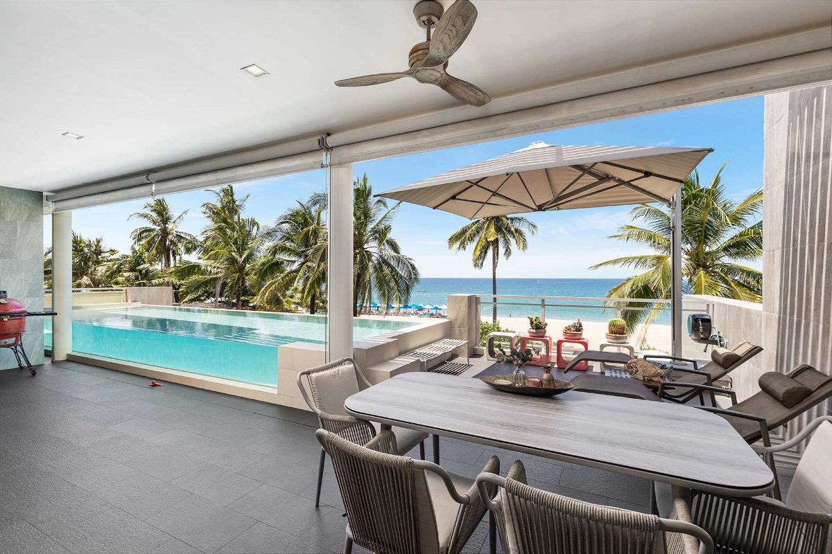 Outdoor terrace with dining and pool views