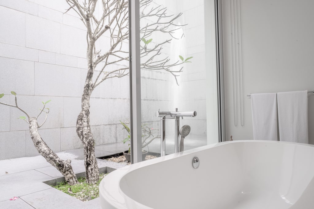 Bathroom with freestanding tub and garden courtyard