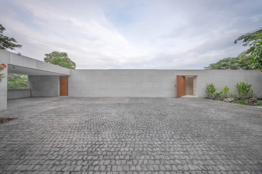 Grand entrance with cobblestone driveway and landscaped gardens